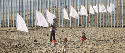 Instalación con banderas blancas en muro EEUU-México tributa a inmigrantes