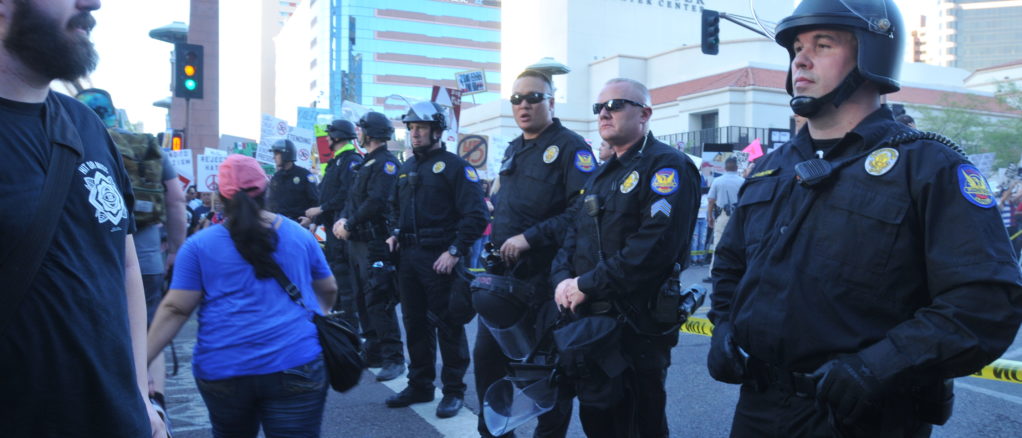 Manifestantes protestan a las puertas del Centro de Convenciones de Phoenix donde Donald Trump ofrece un mitin