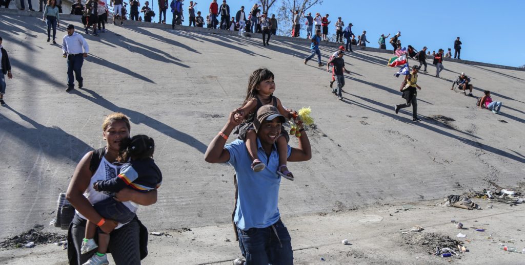 Migrantes intentan cruzar muro con EE.UU. y reciben gas lacrimógeno