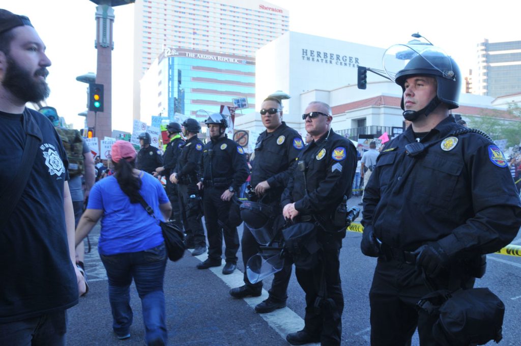 Manifestantes protestan a las puertas del Centro de Convenciones de Phoenix donde Donald Trump ofrece un mitin